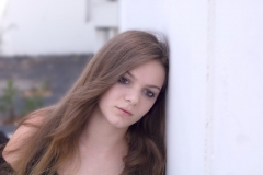Goth teen girl leaning against wall