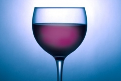 Glass of wine silhouetted against blue spotlight